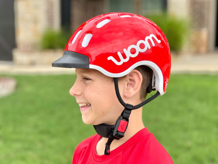 Boy wearing woom kids helmet in red