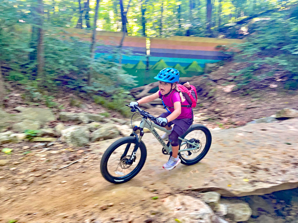 Child riding over rock slab on Prevelo Zulu Three
