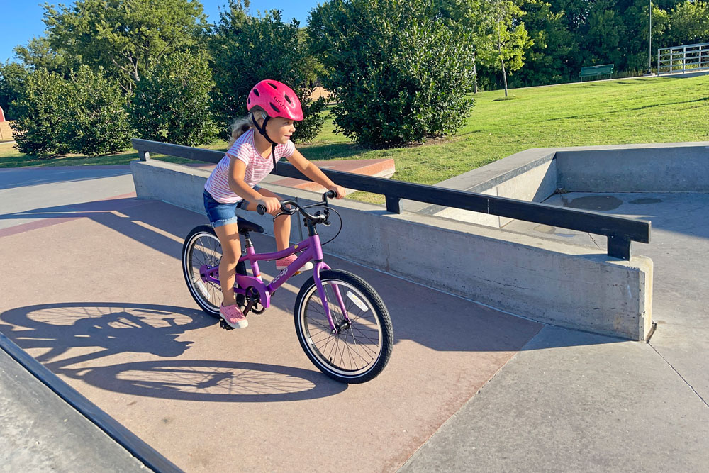 young girl riding the rei co-op rev