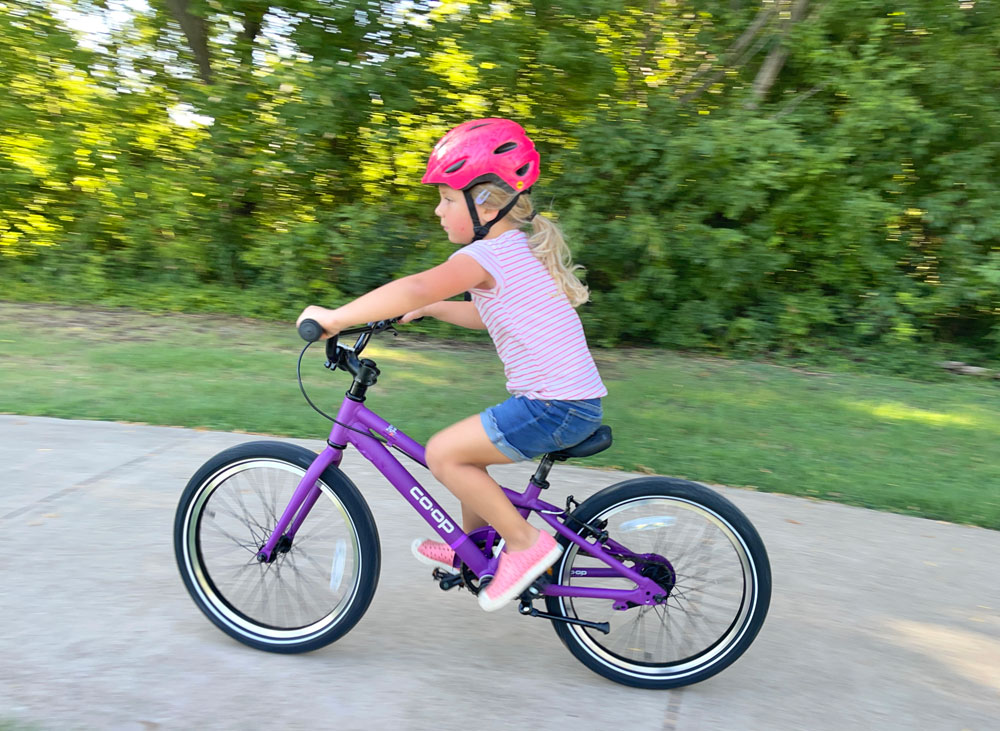 Young girl riding purple REI kids bike