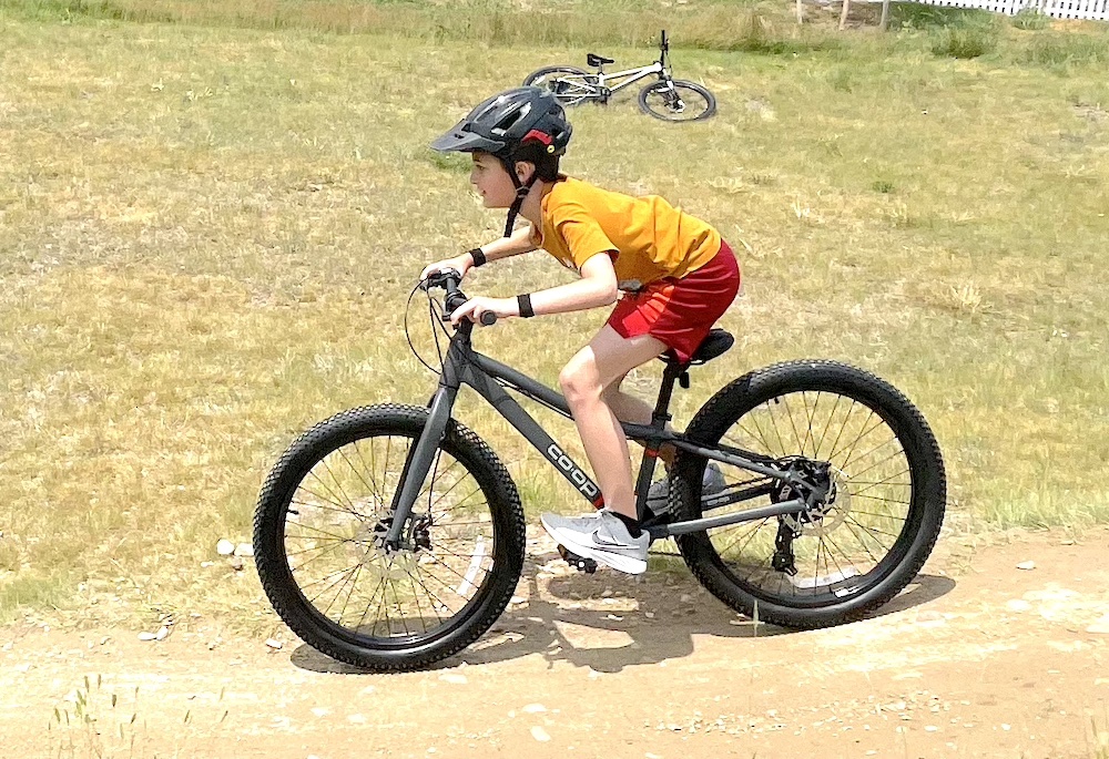 child riding the 24" REI REV kids mountain bike