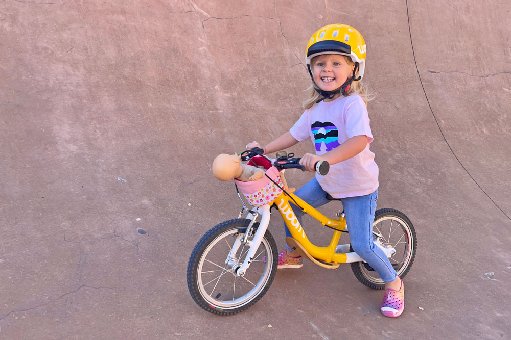 2 year old riding woom balance bike and wearing woom bike helmet size small