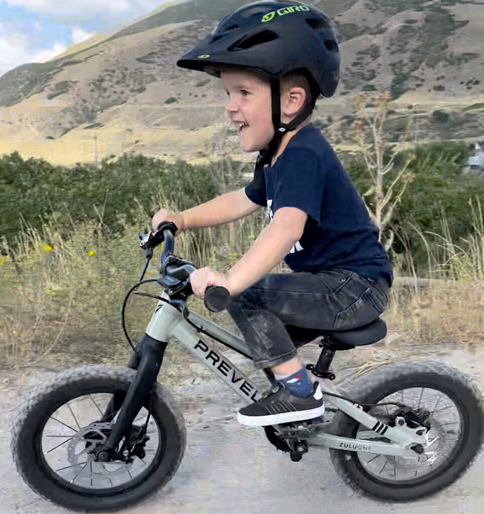 Young boy riding Prevelo 14" mountain bike for kids on dirt trail