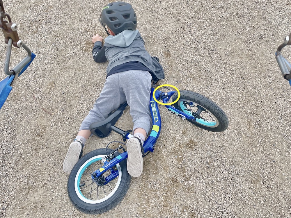 a child who has fallen on his balance bike, but the turning limiter allowed the handlebars to lie flat
