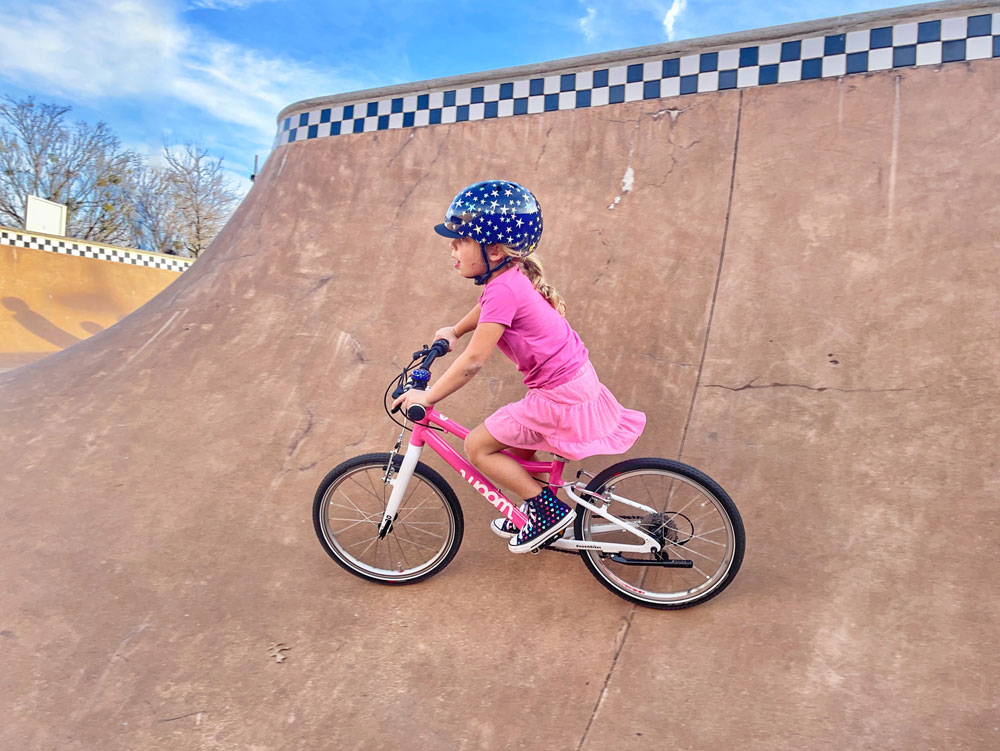 Child wearing Little Nutty bike helmet while riding her bike at the skatepark