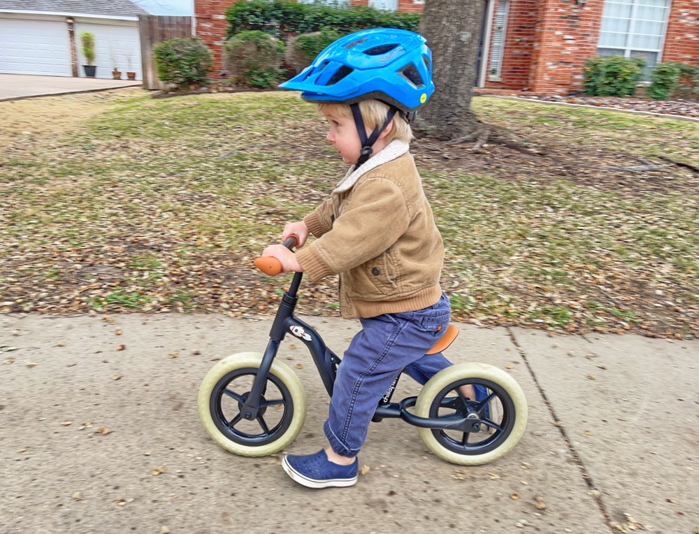 2 year old riding Chillafish Charlie balance bike down the sidewalk
