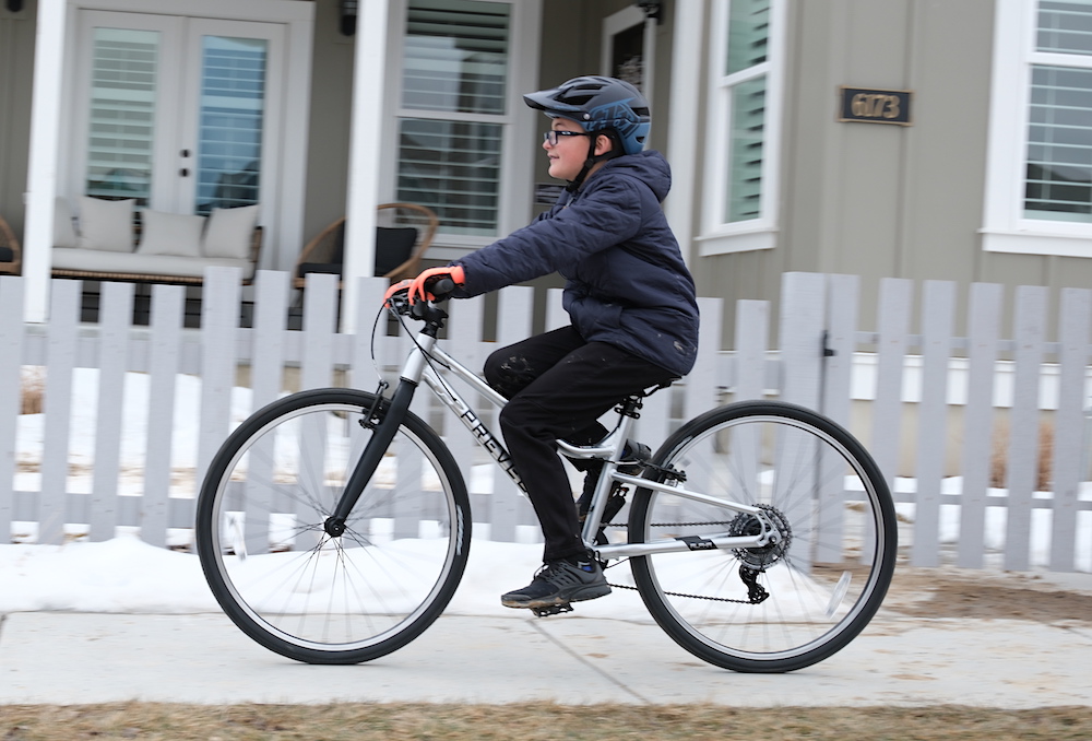 child riding the Prevelo Alpha Five 26" kids bike