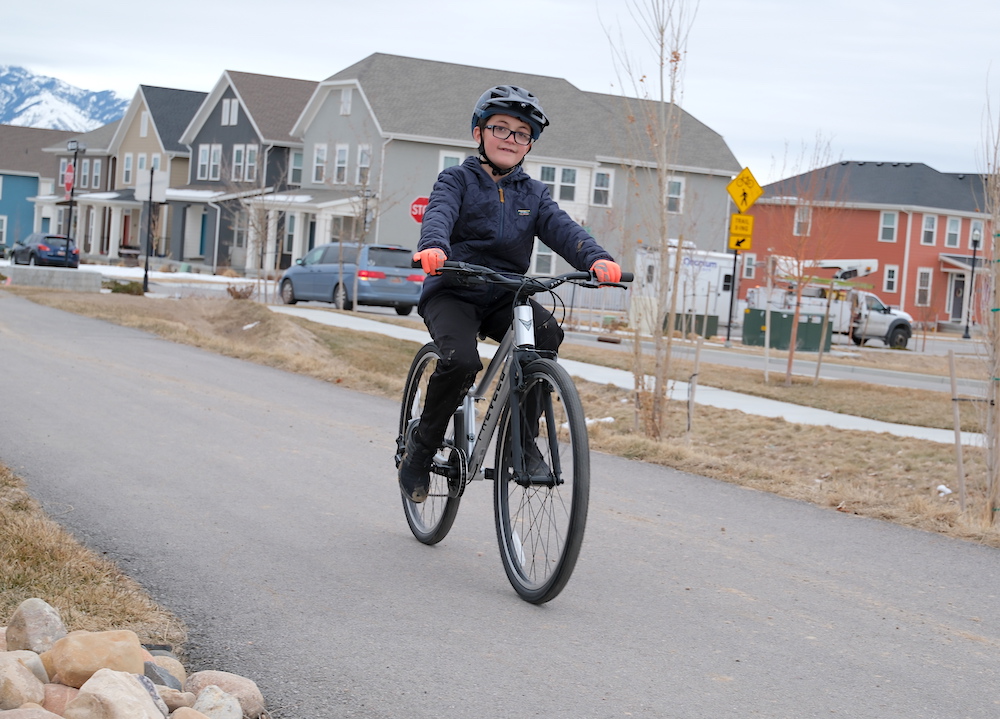 11 year old riding the Prevelo Alpha Five bike on a paved bike path