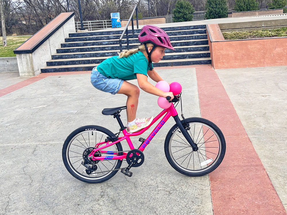 Young rider standing on frame of Prevelo Alpha Three while riding