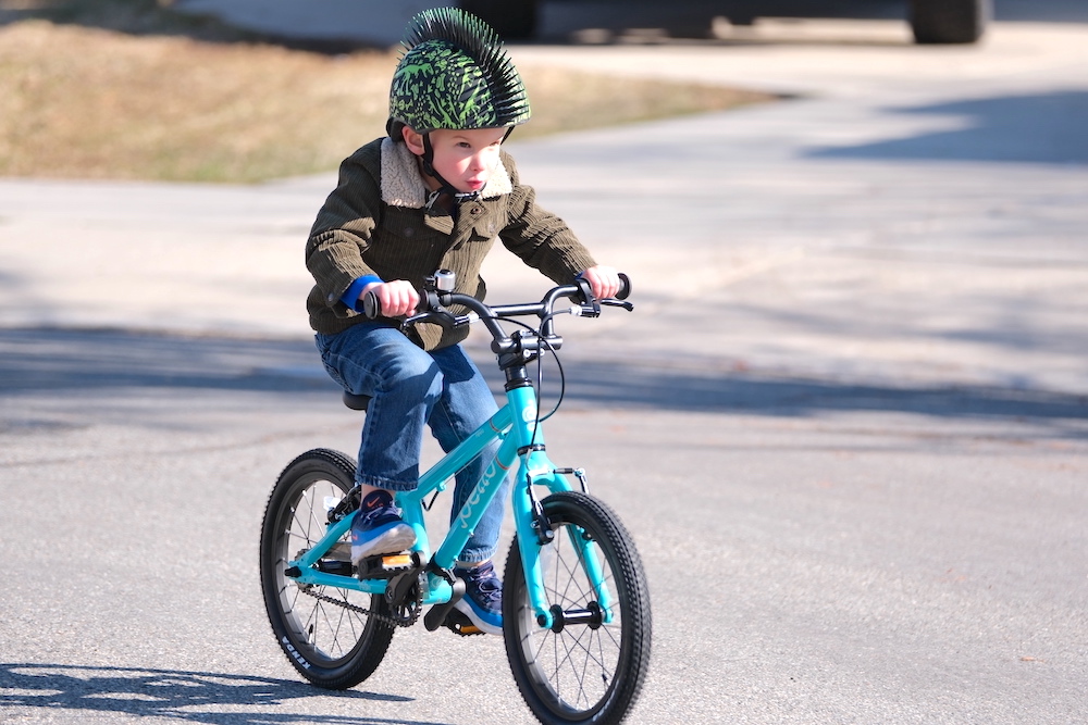 boy riding a teal pello revo 16 inch bike