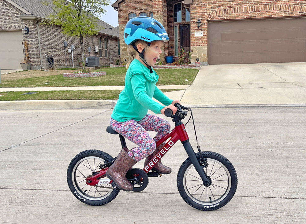 3 year old riding 2023 red Prevelo Alpha One down the street.