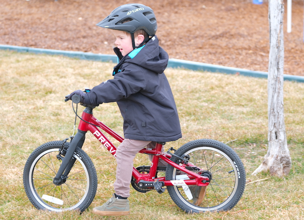 young rider walking on the 16" Prevelo Alpha Two bike