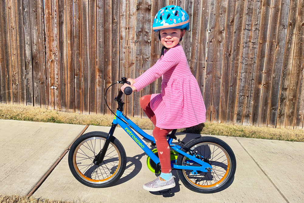 Girl riding 16" Retrospec Koda 2 Plus down the sidewalk
