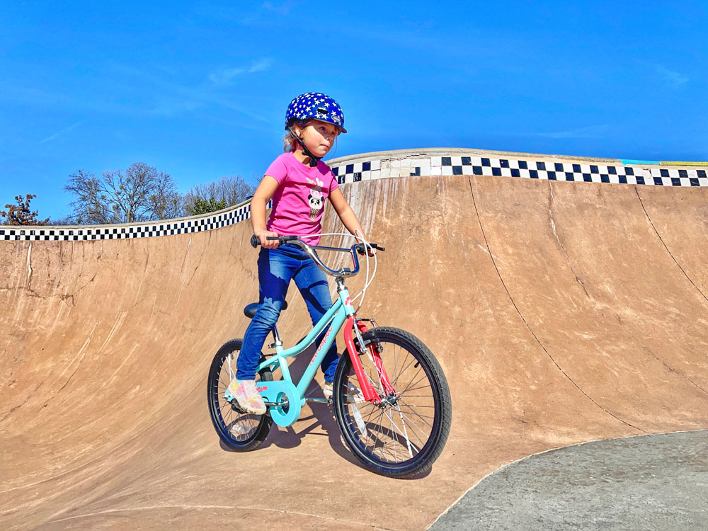 5 year old girl riding 20" Retrospec Koda 2 kids bike in the bowl of a skatepark