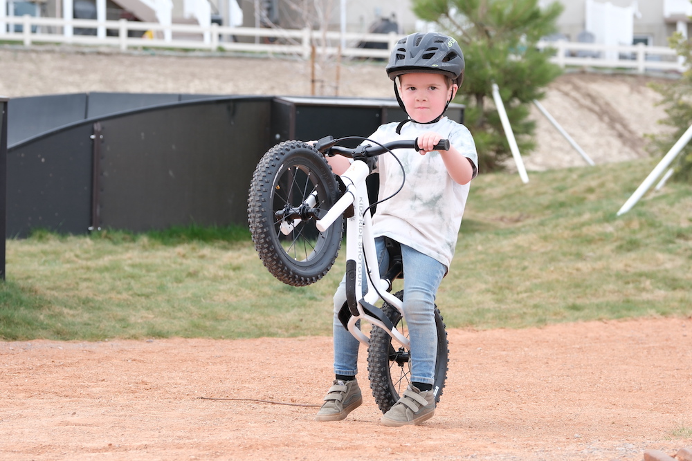 young boy doing a wheelie on his Kids Ride Shotgun off-road balance bike
