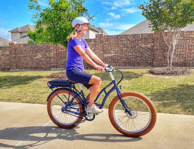 woman riding Priority eCoast electric bike down the sidewalk