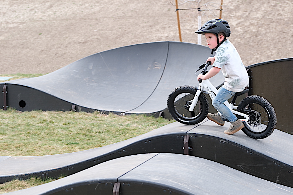 Boy riding on a pump track on a balance bike