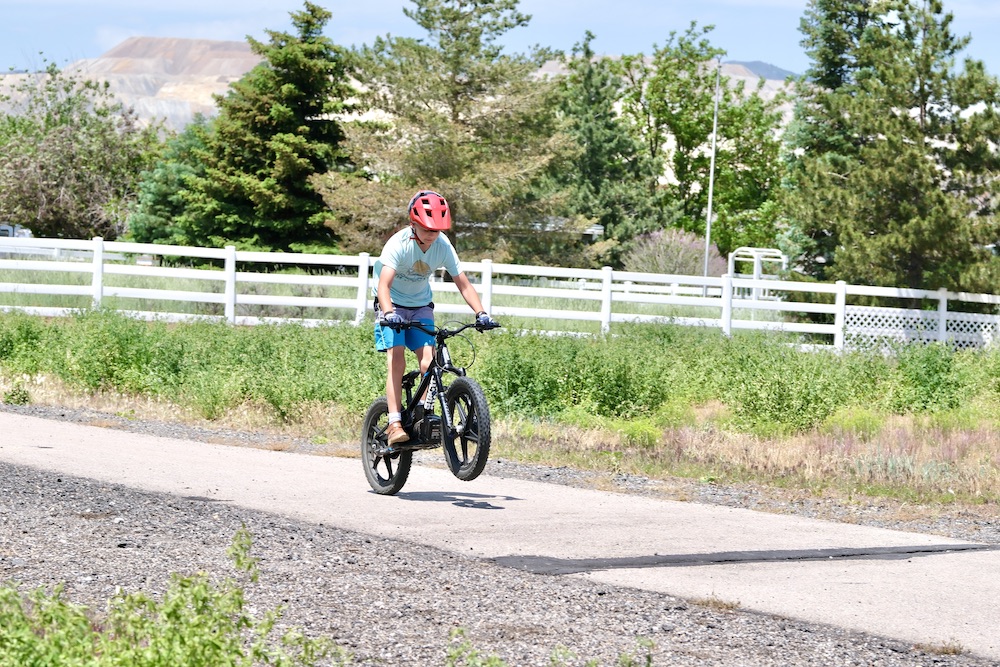 young riding doing a wheelie on the STACYC 20" bike