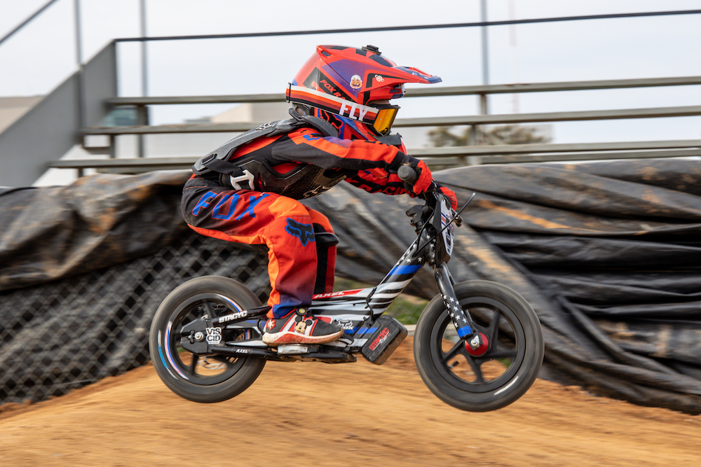 young child racing on his stacyc 12 inch bike