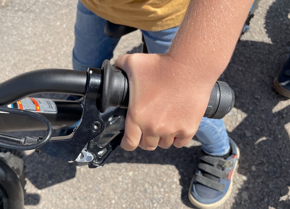 young boy pulling on the brake handle on of the stacyc