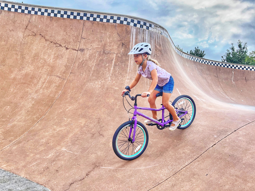 Giril riding aggressively at the skatepark on her Guardian 20 inch bike
