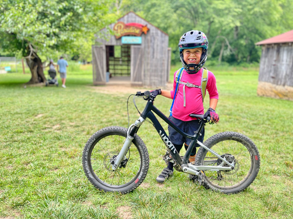 5 year old standing next to woom OFF AIR 4 at Coler MTB Preserve