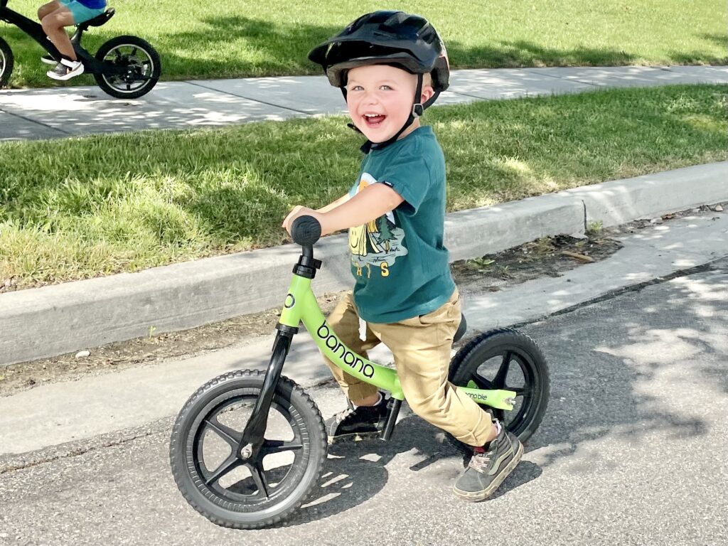 young boy smiling as he rides the banana bike GT balance bike