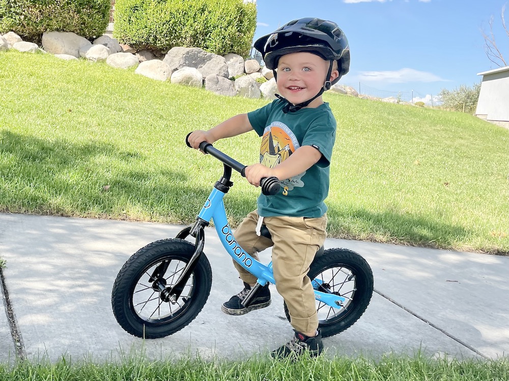 young boy smiling as he rides the banana bike GT