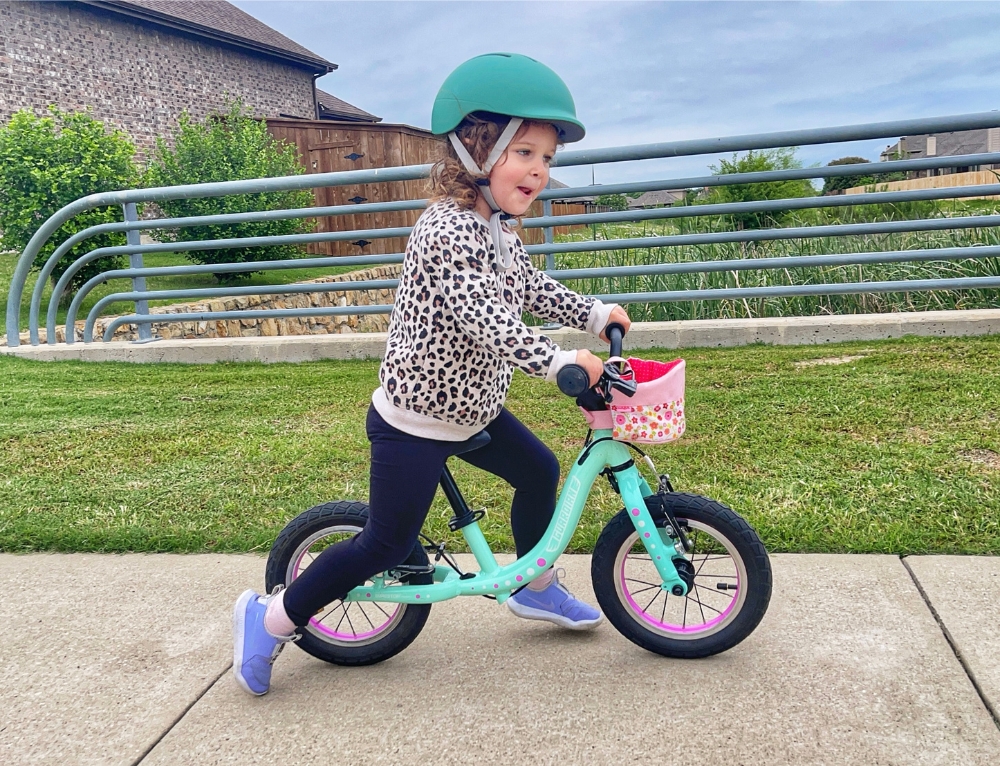 3 year old riding Guardian balance bike on the sidewalk