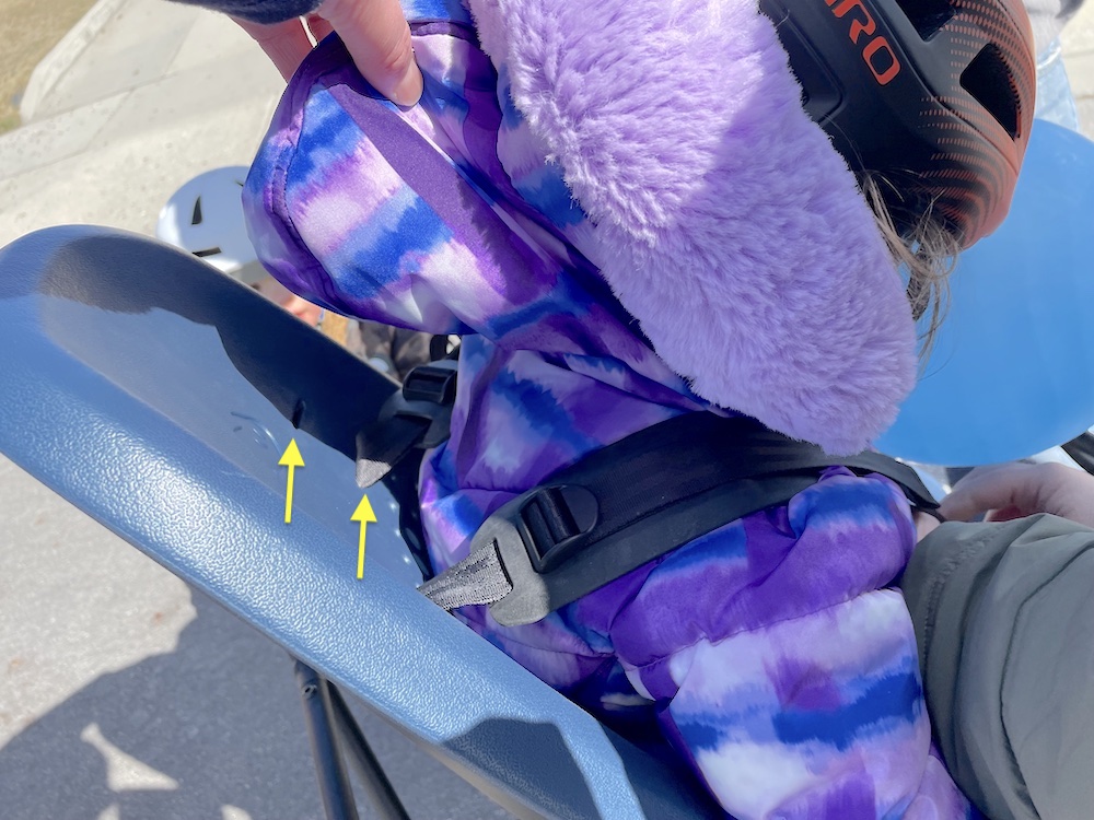 Child sitting in Yepp 2 with the shoulder strap in its lower position