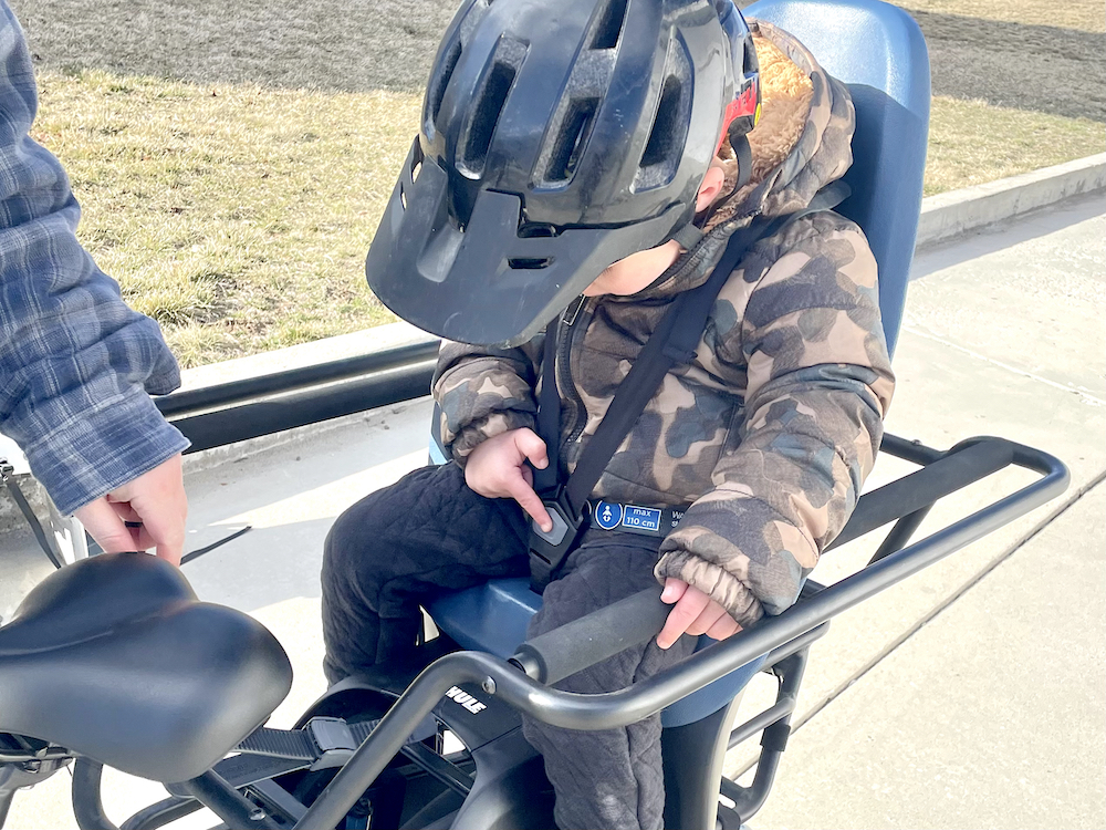 Toddler trying to unbuckle himself in the Thule Yepp 2 maxi child bike seat
