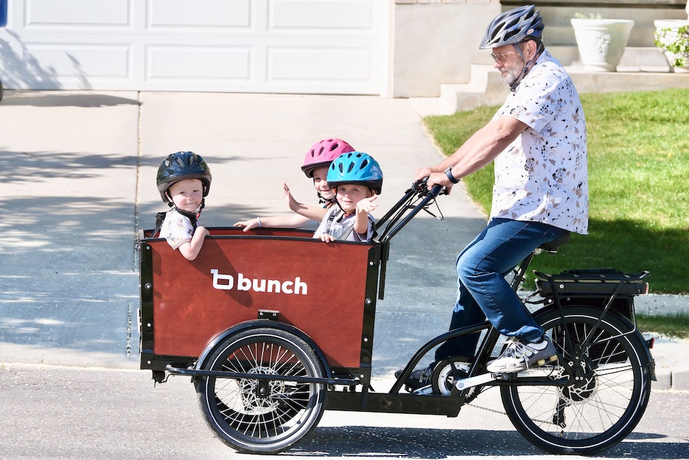grandpa riding the Bunch Bike with three kids in the front box