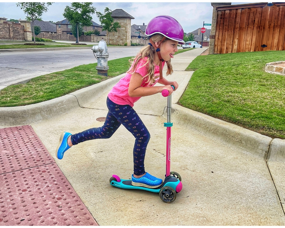 Young girl riding GOMO 3 wheel scooter in the neighborhood