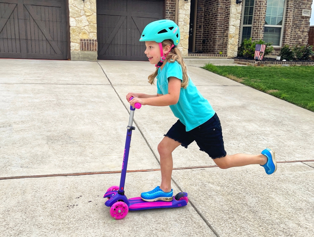 Young girl riding a scooter and wearing Giro Scamp II helmet