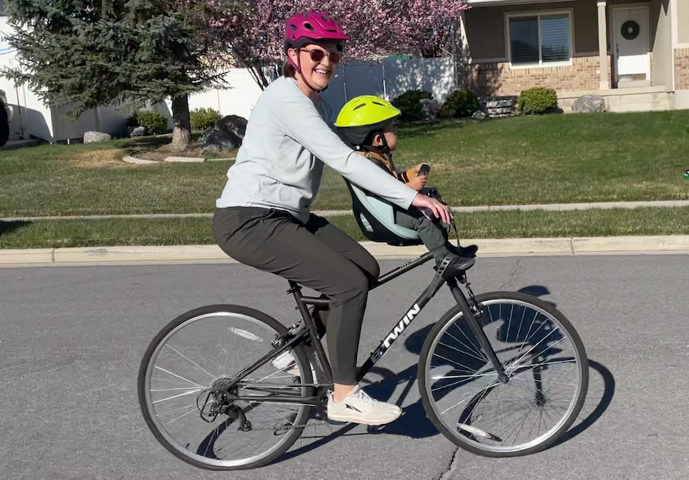 women riding a bike with a child in the Thule front mounted bike seat
