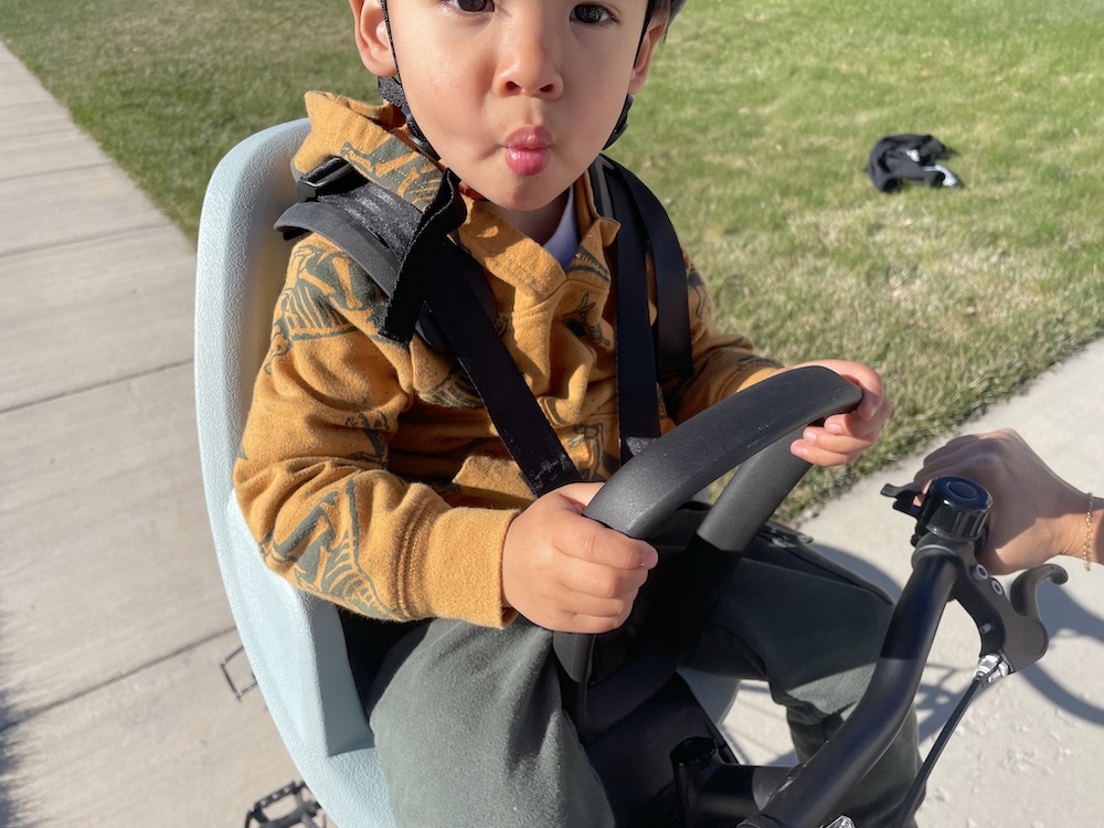 child holding on to the u shaped handlebar on the Yepp Mini 2