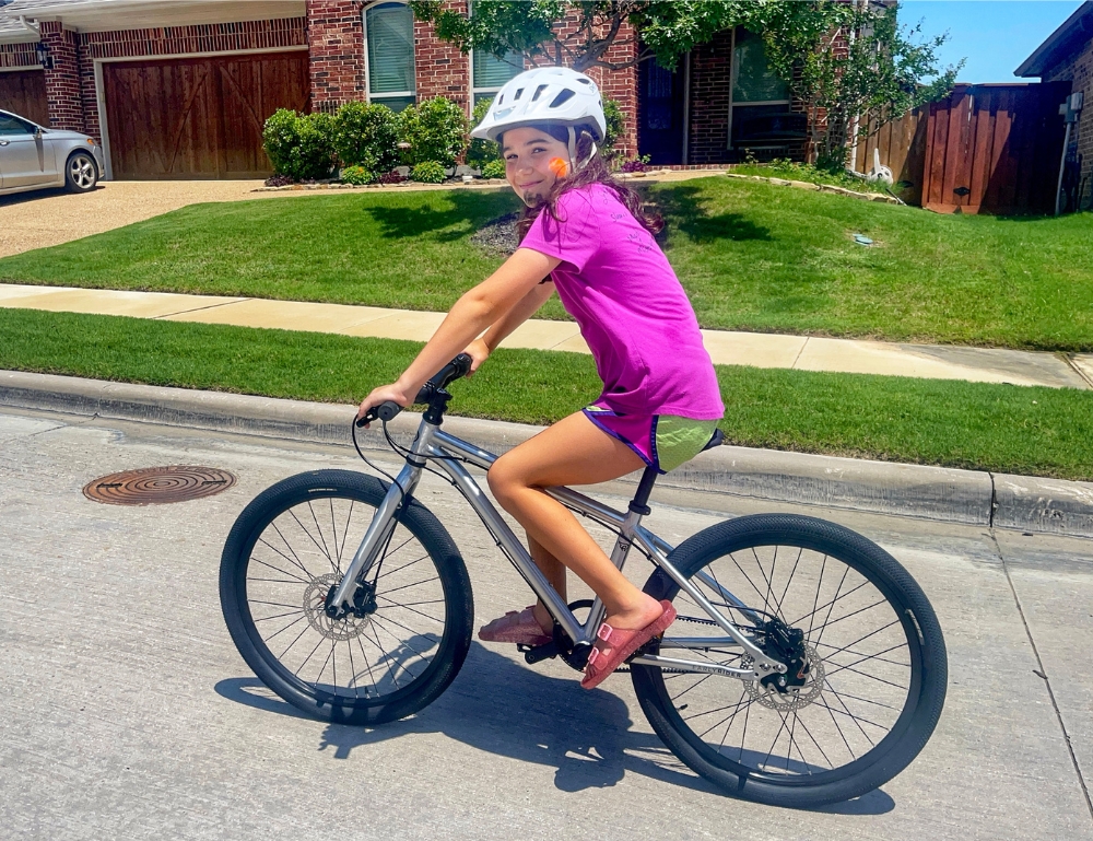 10 year old rider on Early Rider Belter 24, riding on neighborhood street