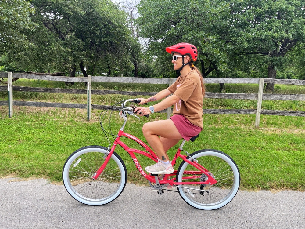 Woman riding Electra Cruiser down country road