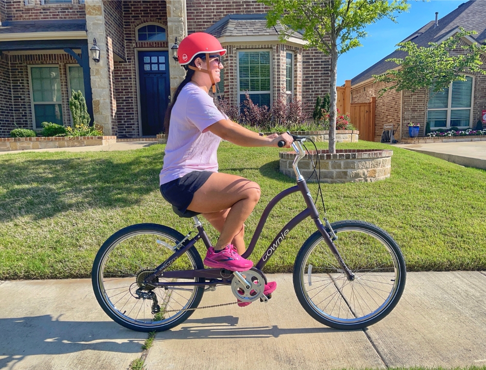 Woman riding Electra Townie 7D down the sidewalk