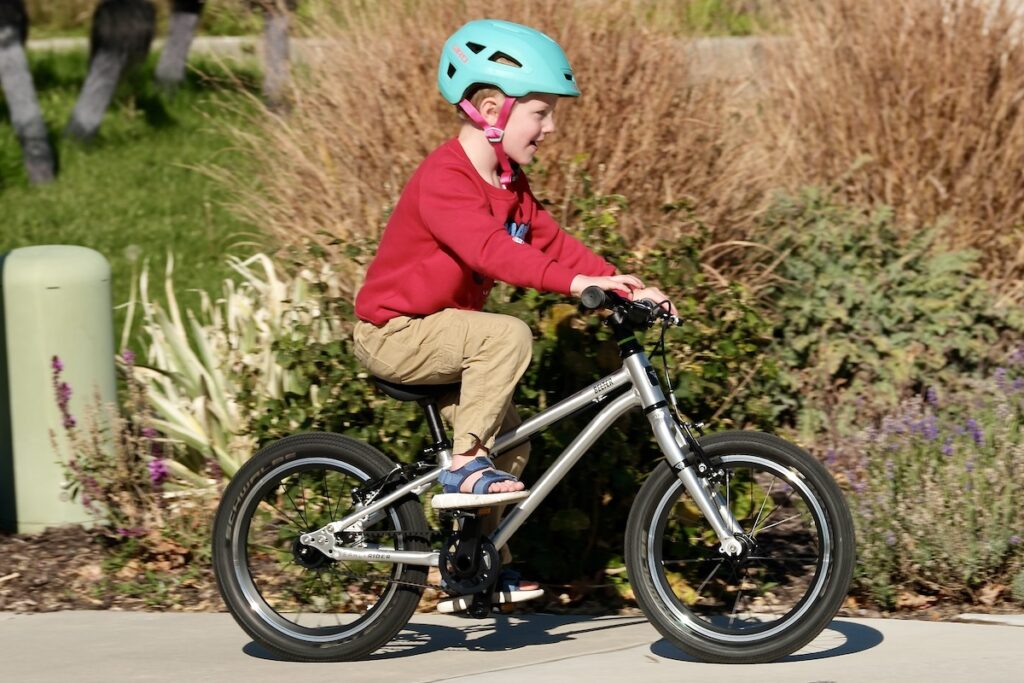 young boy riding the early rider belter 16
