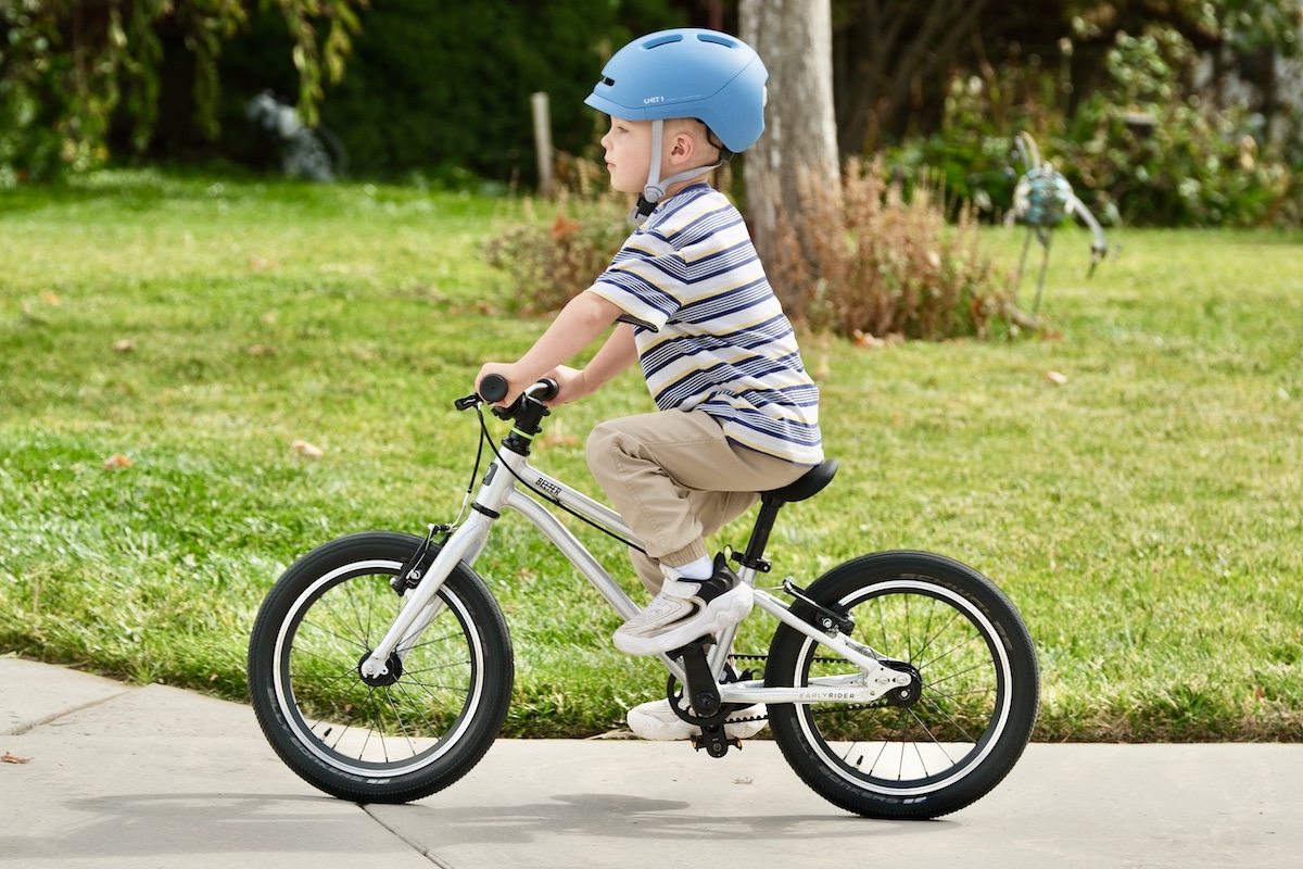 young boy riding the early rider belter 16
