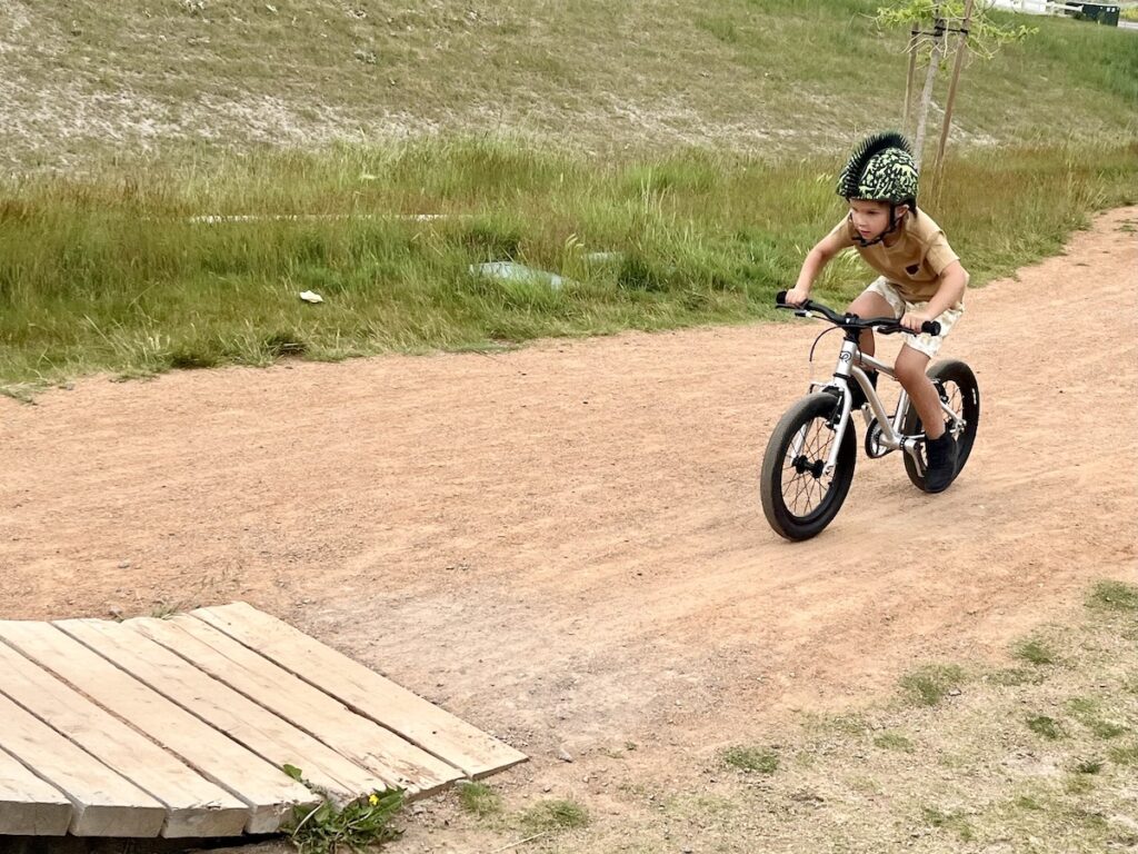 Young rider gaining speed to head up a ramp at the bike park