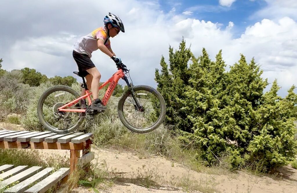 young rider jumping the specialized eMTB for kids