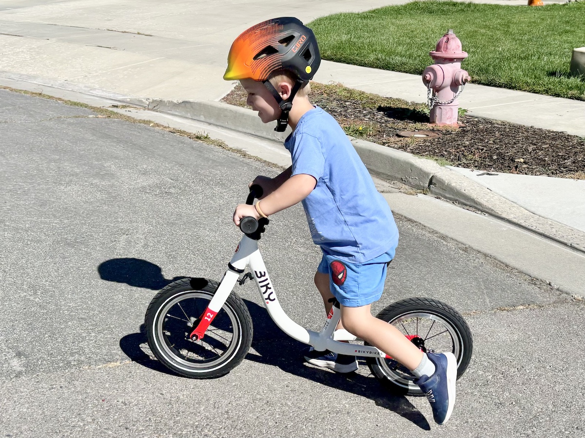 an older 3T toddler riding the biky bikes balance bike
