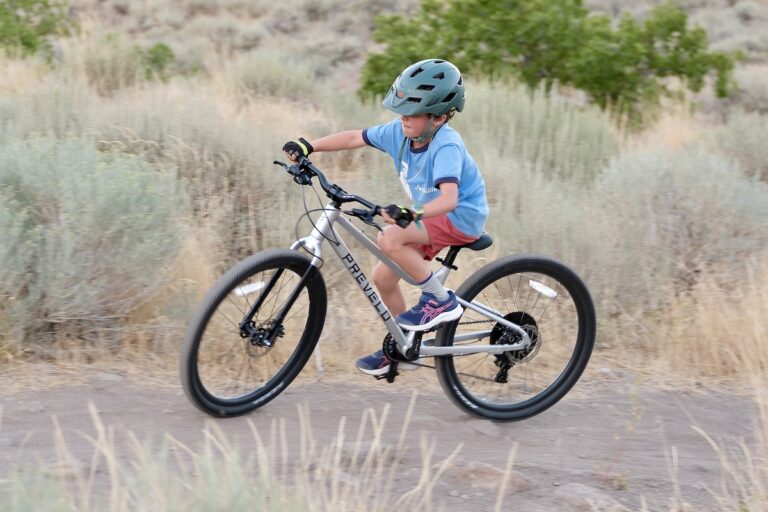 kid riding the Prevelo Alpha Four 24” bike up a MTB trail