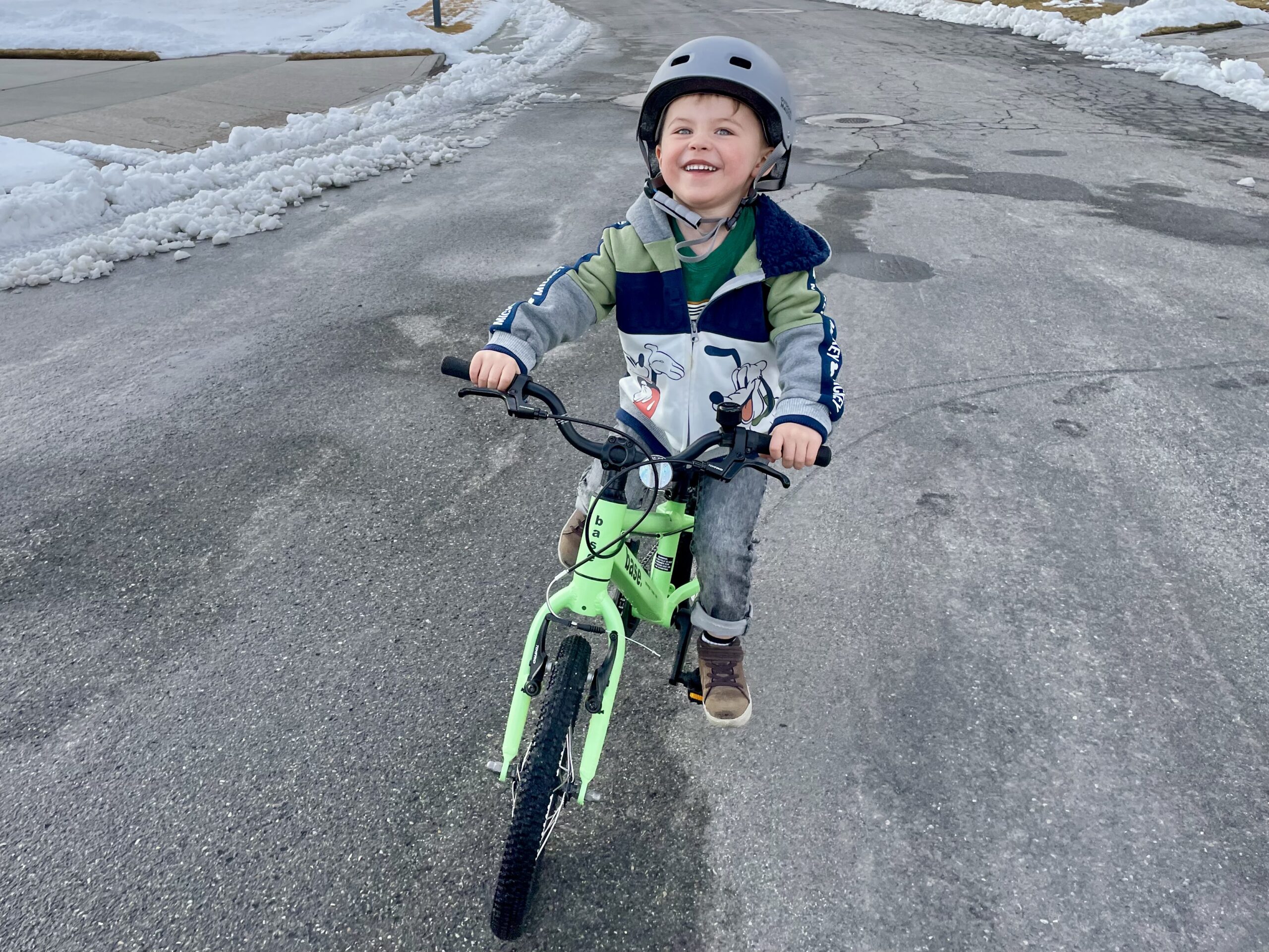 young child riding the 16 inch green base bike
