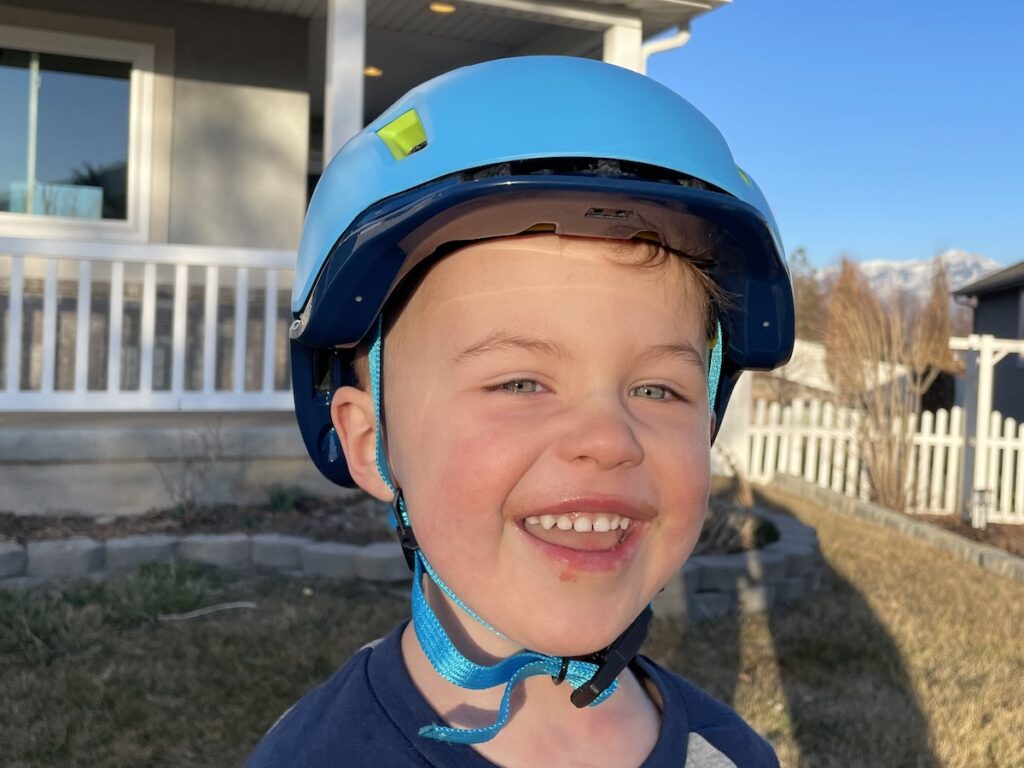 toddler wearing the ozmo helmet while smiling
