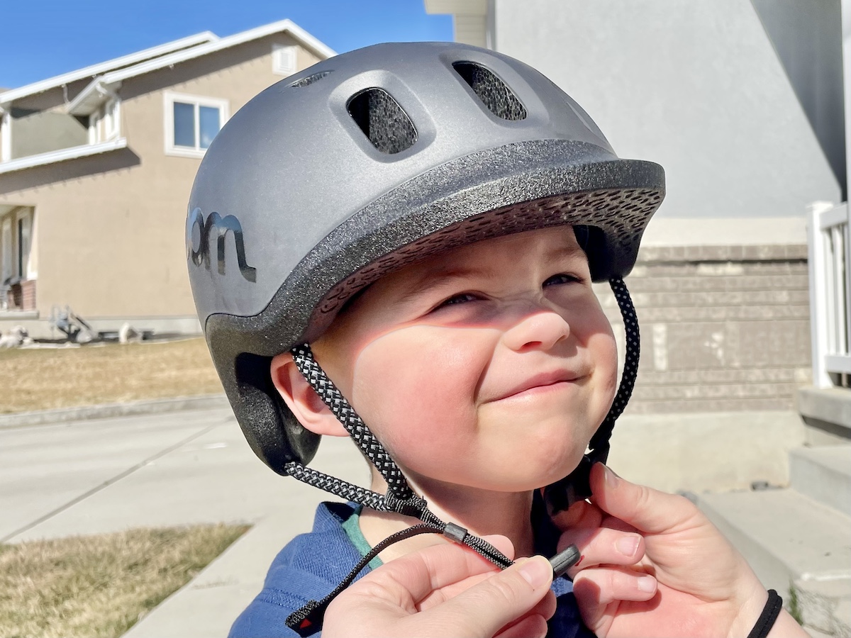 black woom READY helmet being buckled by a mom