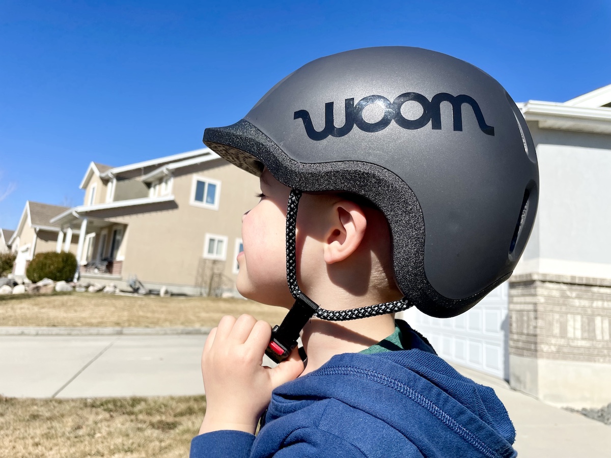 side profile of a toddler wearing a black woom READY bike helmet