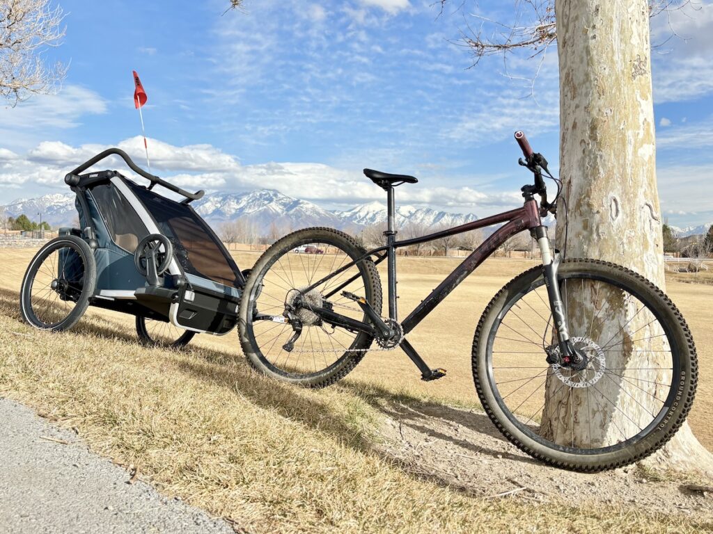 thule cross bike trailer leaned against a tree
